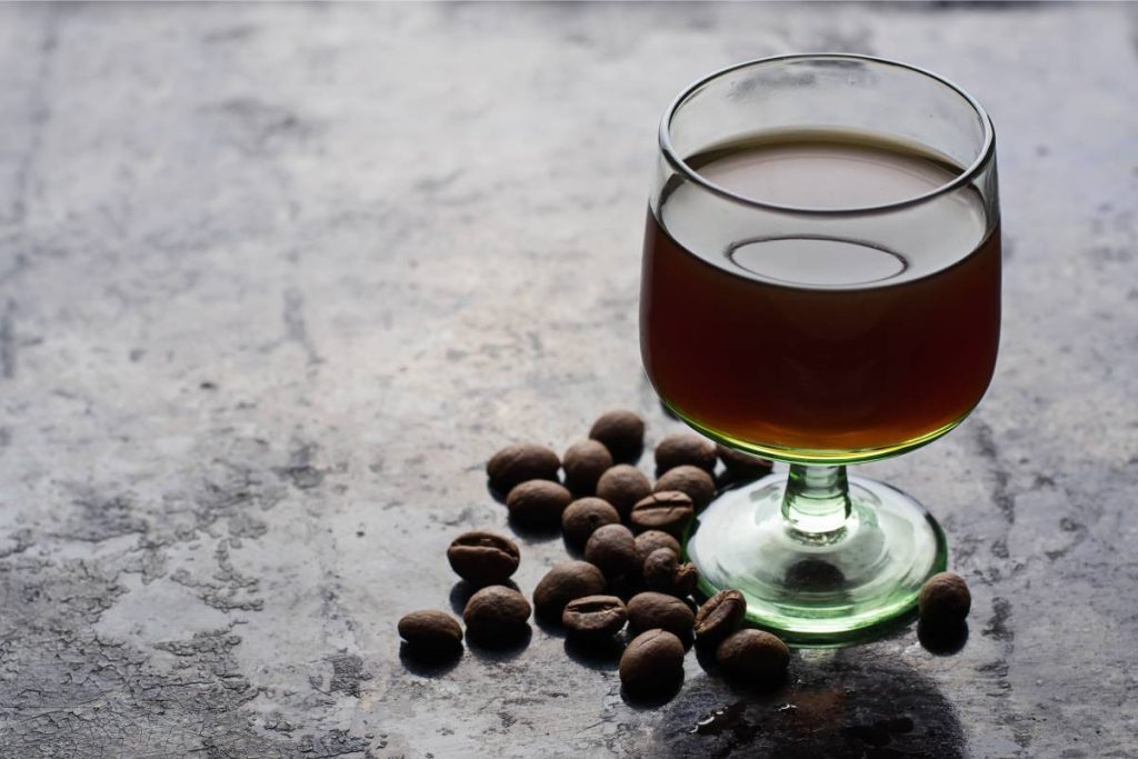 Glass of coffee liquor and coffee beans. Selective focus