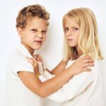 The boy is offended by the little girl fight naughty isolated background